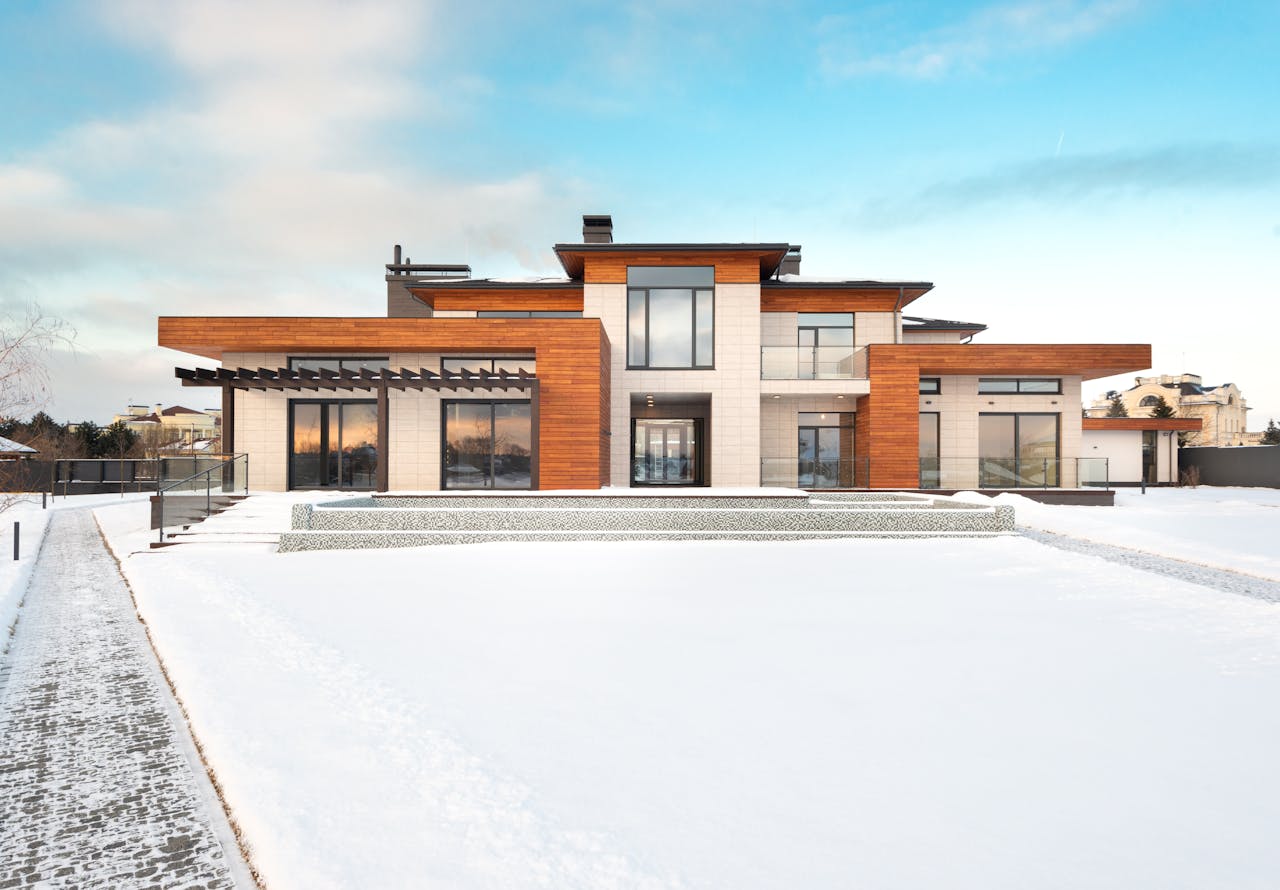 Contemporary house with wooden facade in snowy landscape, ideal for winter real estate.